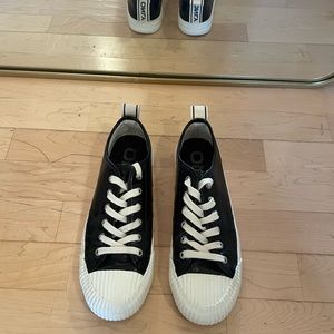 Only Brand black shiny sneaker with white sole and round toe.